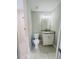 Bright bathroom featuring tiled floors, granite vanity top, a toilet and a tiled shower with a glass door at 1522 Kettles Ave, Lakeland, FL 33805