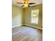 Cozy bedroom featuring a window, ceiling fan, and wood-look flooring at 1522 Kettles Ave, Lakeland, FL 33805