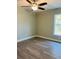 Cozy bedroom featuring laminate floors, neutral colored walls, a ceiling fan, and a window with natural light at 1522 Kettles Ave, Lakeland, FL 33805