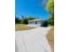 Single-story home featuring a neutral color scheme, a long driveway, and lush greenery in a serene neighborhood at 1522 Kettles Ave, Lakeland, FL 33805