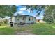 Spacious backyard featuring a cozy outdoor seating area under a covered patio and mature shade trees at 1610 Reynolds Rd # 50, Lakeland, FL 33801