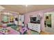 Bedroom with pink walls, dresser with TV, and decorative floral bedding at 1610 Reynolds Rd # 50, Lakeland, FL 33801