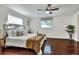 Bright main bedroom featuring hardwood floors, ceiling fan, bright natural light, and stylish decor at 1655 John Arthur Way, Lakeland, FL 33803