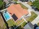 Aerial view of a pool, solar panels, fence, and tile roof at 1931 Matthew Ct, Lakeland, FL 33813