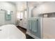 Bright bathroom featuring a modern soaking tub, a stylish vanity, and a glass-enclosed shower with decorative mosaic tile at 1931 Matthew Ct, Lakeland, FL 33813