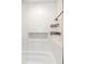 Bathroom with a white tiled shower, built-in niche, and black metal wall-mounted storage shelves at 1931 Matthew Ct, Lakeland, FL 33813
