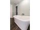Bright bathroom featuring a modern soaking tub with chrome fixtures and dark wood flooring for a relaxing spa experience at 1931 Matthew Ct, Lakeland, FL 33813