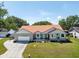 Charming single-story home boasts a well-manicured lawn, red roof, and attached two-car garage at 1931 Matthew Ct, Lakeland, FL 33813