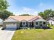 Charming single-story home with a two-car garage, beautiful landscaping, and inviting front entrance at 1931 Matthew Ct, Lakeland, FL 33813