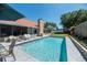 Backyard pool with patio seating, lush greenery, and a view of the home's exterior at 1931 Matthew Ct, Lakeland, FL 33813