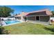 Outdoor pool area with solar panels, a well-kept lawn, and a privacy fence at 1931 Matthew Ct, Lakeland, FL 33813