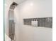 Contemporary shower showcasing a sleek multi-functional shower panel and niche with modern gray, honeycomb style tiles at 1931 Matthew Ct, Lakeland, FL 33813