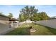Fenced backyard with a fire pit, mature trees, and storage shed at 2104 W End Ave, Lakeland, FL 33803