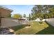 Fenced backyard with a fire pit, mature trees, bird bath, and storage shed at 2104 W End Ave, Lakeland, FL 33803