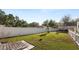 Spacious, fenced-in backyard offers a tranquil setting with mature trees, a bird bath, and manicured lawn at 2104 W End Ave, Lakeland, FL 33803