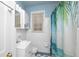 A well lit bathroom with white tile, modern fixtures, and a shower with palm tree curtain at 2104 W End Ave, Lakeland, FL 33803