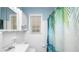 A bright bathroom featuring white tile, updated fixtures, and a playful tropical-themed shower curtain at 2104 W End Ave, Lakeland, FL 33803