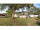 Single-story home with well-maintained lawn, showcasing classic architectural details and mature trees for added charm at 2104 W End Ave, Lakeland, FL 33803