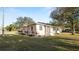Charming single-story home featuring a manicured lawn, mature trees, and a welcoming entrance at 2104 W End Ave, Lakeland, FL 33803