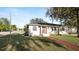 Charming single-story home with a red brick walkway, lush lawn, and mature trees adding character and curb appeal at 2104 W End Ave, Lakeland, FL 33803