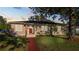 Charming single-story home boasting a well-maintained lawn, red brick walkway, and large shade tree at 2104 W End Ave, Lakeland, FL 33803