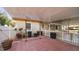 Covered patio featuring brick flooring, a ceiling fan, and a white picket fence at 2104 W End Ave, Lakeland, FL 33803