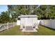 A backyard storage shed is enclosed by a white picket fence and mature trees at 2104 W End Ave, Lakeland, FL 33803