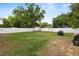 Fenced backyard featuring a storage shed, a fire pit, well-manicured lawn, and mature trees at 2111 S Lincoln Ave, Lakeland, FL 33803