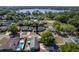 Suburban homes featuring a pool and lake views, surrounded by lush greenery and mature trees at 221 Stevenson Rd, Winter Haven, FL 33884