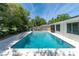 Beautiful backyard features a sparkling blue pool, patio area, and lush landscaping at 221 Stevenson Rd, Winter Haven, FL 33884