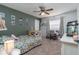 Bedroom with floral bedding, ceiling fan, neutral carpet, pictures on the wall, and desk and chair at 221 Stevenson Rd, Winter Haven, FL 33884