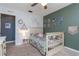 Bedroom with a crib, flower bedding, personal photos, and a side table with a lamp at 221 Stevenson Rd, Winter Haven, FL 33884