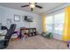 Bright bedroom with carpet floors, yellow curtains, and mounted television at 221 Stevenson Rd, Winter Haven, FL 33884