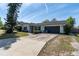 Front exterior featuring a two-car garage, well-manicured lawn, and charming curb appeal at 221 Stevenson Rd, Winter Haven, FL 33884