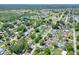 An aerial view of a property with a backyard pool surrounded by lush green trees and neighborhood at 2329 Duff Rd, Lakeland, FL 33810