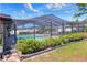 Backyard view of a screened-in pool area surrounded by lush greenery and an inviting outdoor space at 2329 Duff Rd, Lakeland, FL 33810