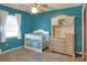 Cozy Bedroom with a crib, dresser, and carpet flooring illuminated by a ceiling fan and natural light at 2329 Duff Rd, Lakeland, FL 33810