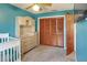 Bedroom features a crib, dresser with hutch, closet with bi-fold doors, carpet and ceiling fan at 2329 Duff Rd, Lakeland, FL 33810