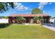 Brick house with green lawn, tropical landscaping and a sidewalk leading to the front door at 2329 Duff Rd, Lakeland, FL 33810