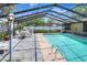 Enclosed turquoise swimming pool with stone accents, and outdoor seating with table and chairs at 2329 Duff Rd, Lakeland, FL 33810