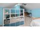 Bright attic bedroom features shelving, a bed, a study desk and blue walls at 2569 Colonel Ford Dr, Lakeland, FL 33813