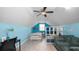 Cozy bedroom features blue walls, a ceiling fan, and a comfortable sitting area with couch and decor at 2569 Colonel Ford Dr, Lakeland, FL 33813