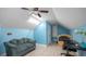 Attic bedroom features blue walls, a ceiling fan, sitting area, study desk, and a bed at 2569 Colonel Ford Dr, Lakeland, FL 33813