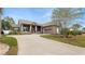 Beautiful home featuring manicured lawn, mature trees and a driveway leading to an attached garage at 2569 Colonel Ford Dr, Lakeland, FL 33813