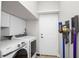 Bright laundry room with washer, dryer, white cabinetry, and convenient access door at 2569 Colonel Ford Dr, Lakeland, FL 33813