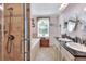 Well-lit bathroom featuring double sinks, a separate shower, and a soaking tub near the window at 2653 State Road 557, Lake Alfred, FL 33850