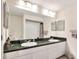 Bathroom with dual sinks, granite counters, and framed mirrors at 2653 State Road 557, Lake Alfred, FL 33850