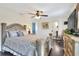 Comfortable bedroom features a ceiling fan, decorative dresser with TV, and wood flooring at 2653 State Road 557, Lake Alfred, FL 33850