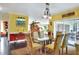 Dining room featuring a glass table, seating for six, and colorful decor, open to other living areas at 2653 State Road 557, Lake Alfred, FL 33850