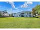 Expansive backyard view of this stately home featuring large balconies and a sunroom at 2653 State Road 557, Lake Alfred, FL 33850